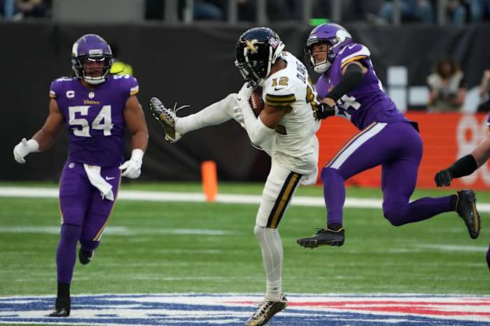 Oct 2, 2022; London, United Kingdom; New Orleans Saints receiver Chris Olave (12) catches a pass between Minnesota Vikings safety Camryn Bynum (24) and linebacker Eric Kendricks (54) during an NFL International Series game at Tottenham Hotspur Stadium. Mandatory Credit: Kirby Lee-USA TODAY Sports